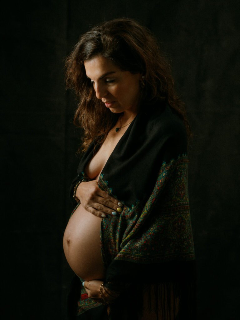 Maryam in moody studio lighting during a maternity portrait shoot in Hamilton