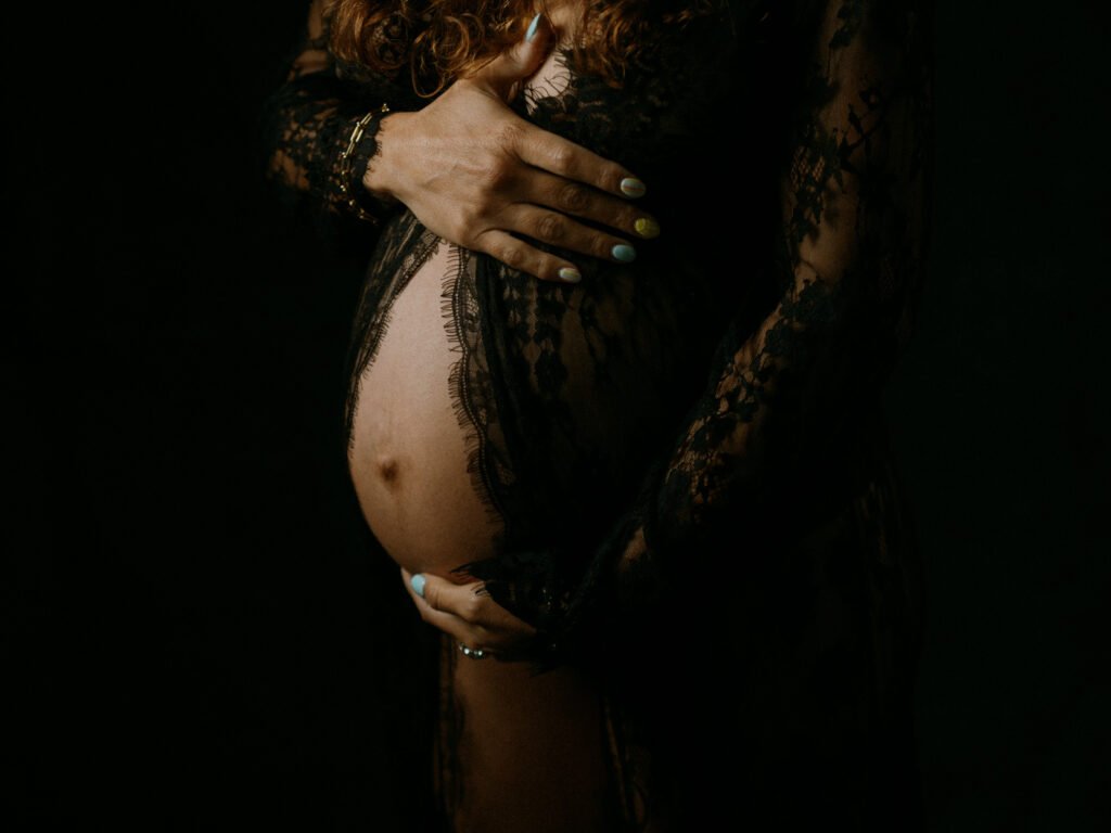 Maryam in moody studio lighting during a maternity portrait shoot in Hamilton