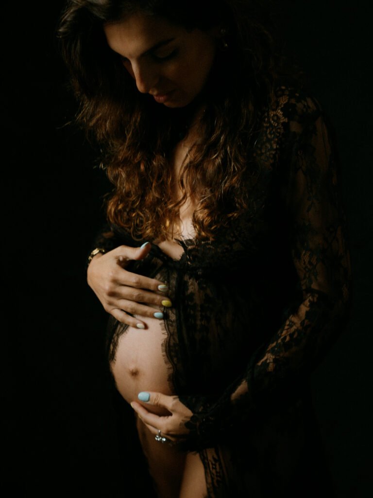 Maryam in moody studio lighting during a maternity portrait shoot in Hamilton