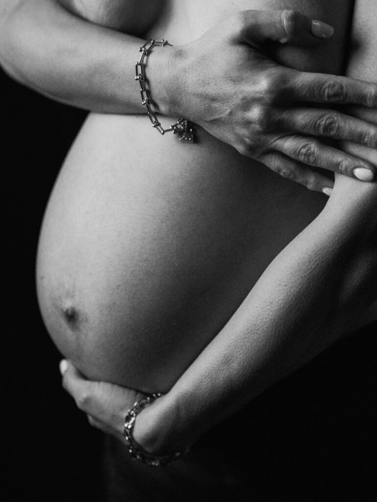 Maryam in moody studio lighting during a maternity portrait shoot in Hamilton