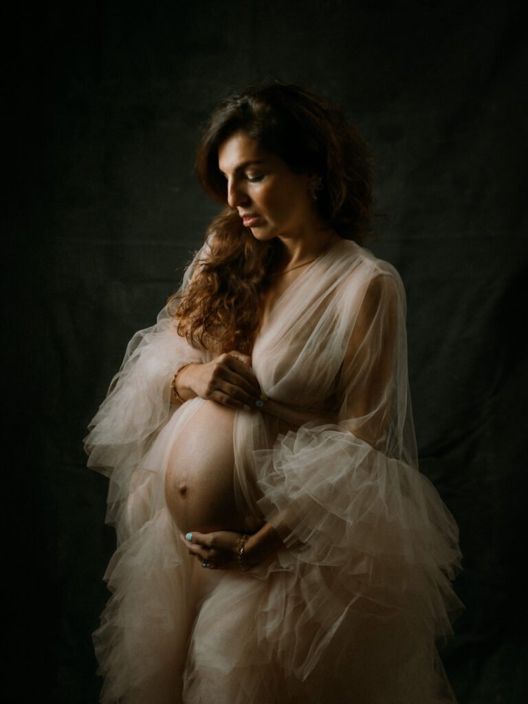 Maryam in moody studio lighting during a maternity portrait shoot in Hamilton